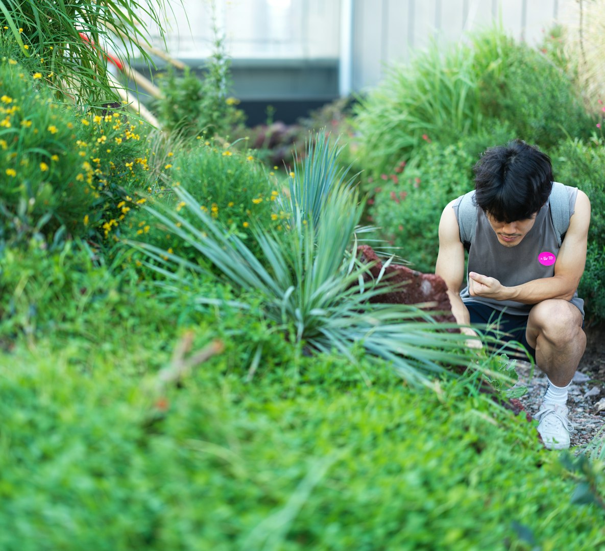 A woman kneeling down in a garden area